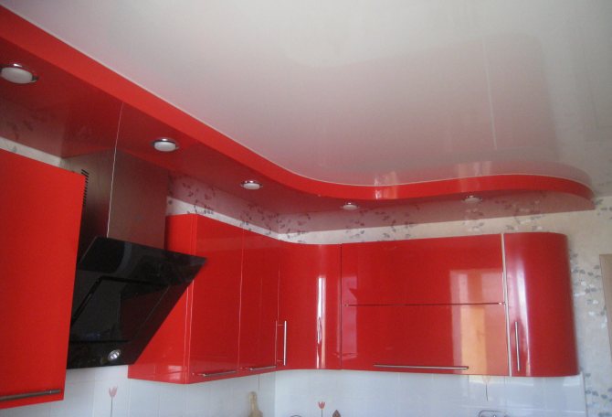 Червен и бял многоетажен опънат таван в кухнята.